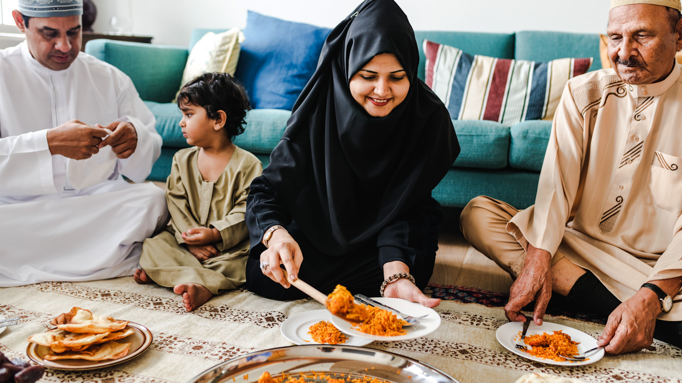 Familia india musulmana comiendo en el suelo