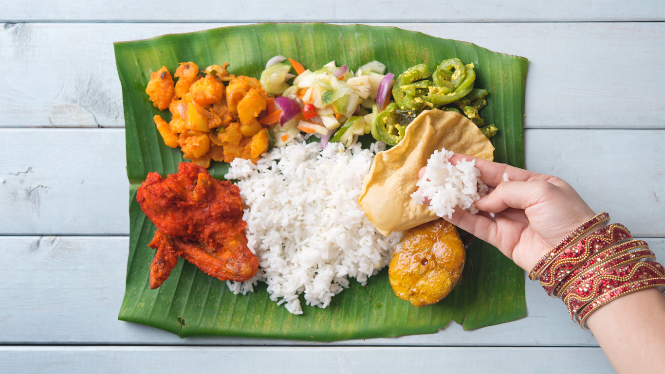 Chica comiendo con la mano un Thali en Kerala