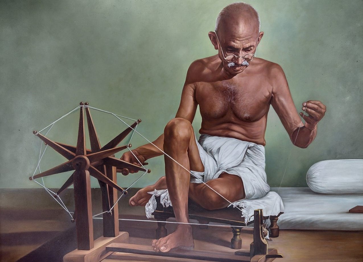 Mahatma Gandhi spinning with his famous spinning wheel